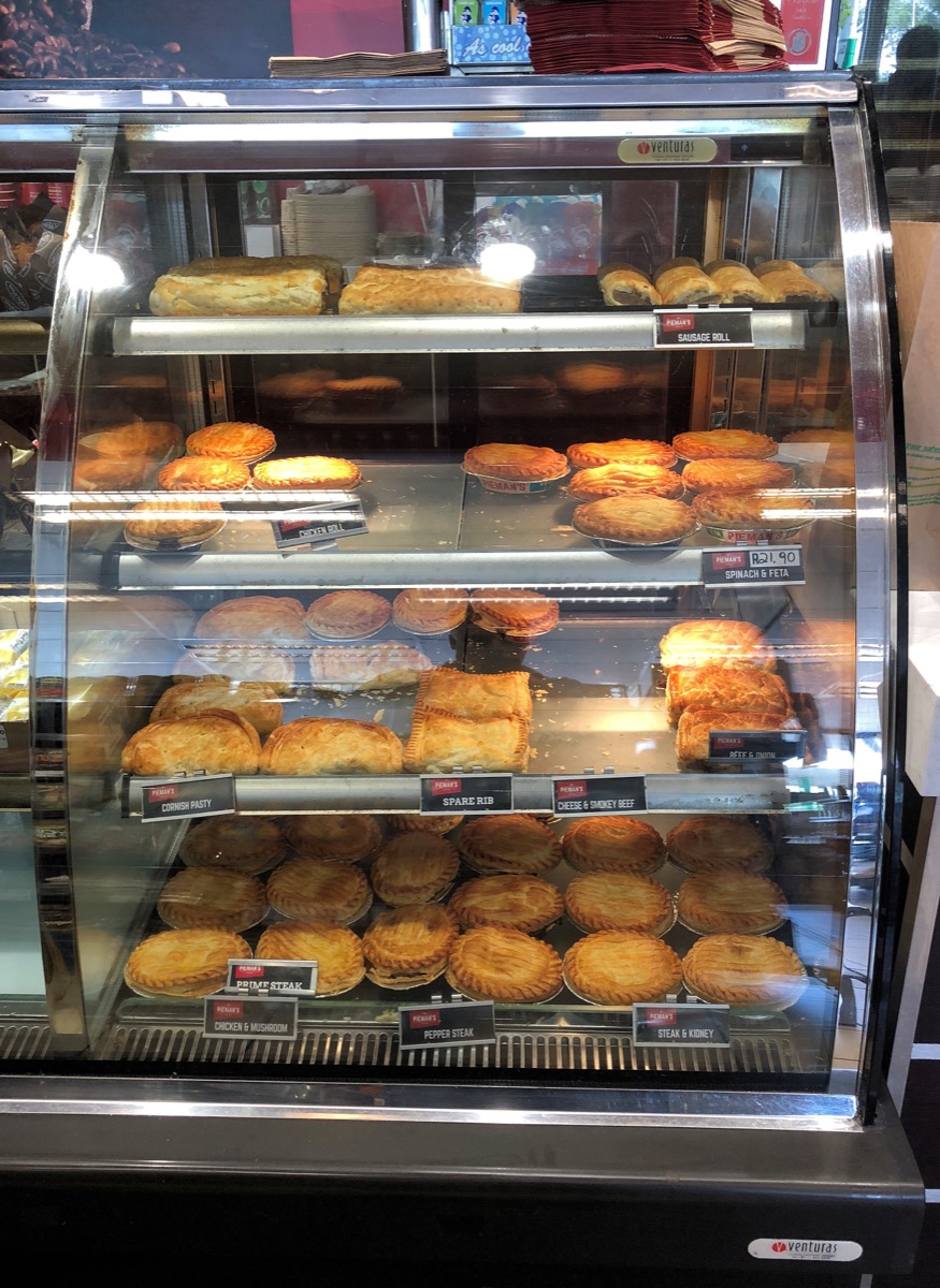 A warming cabinet full of golden, flaky beef and meat hand pies at a filling-station convenience store