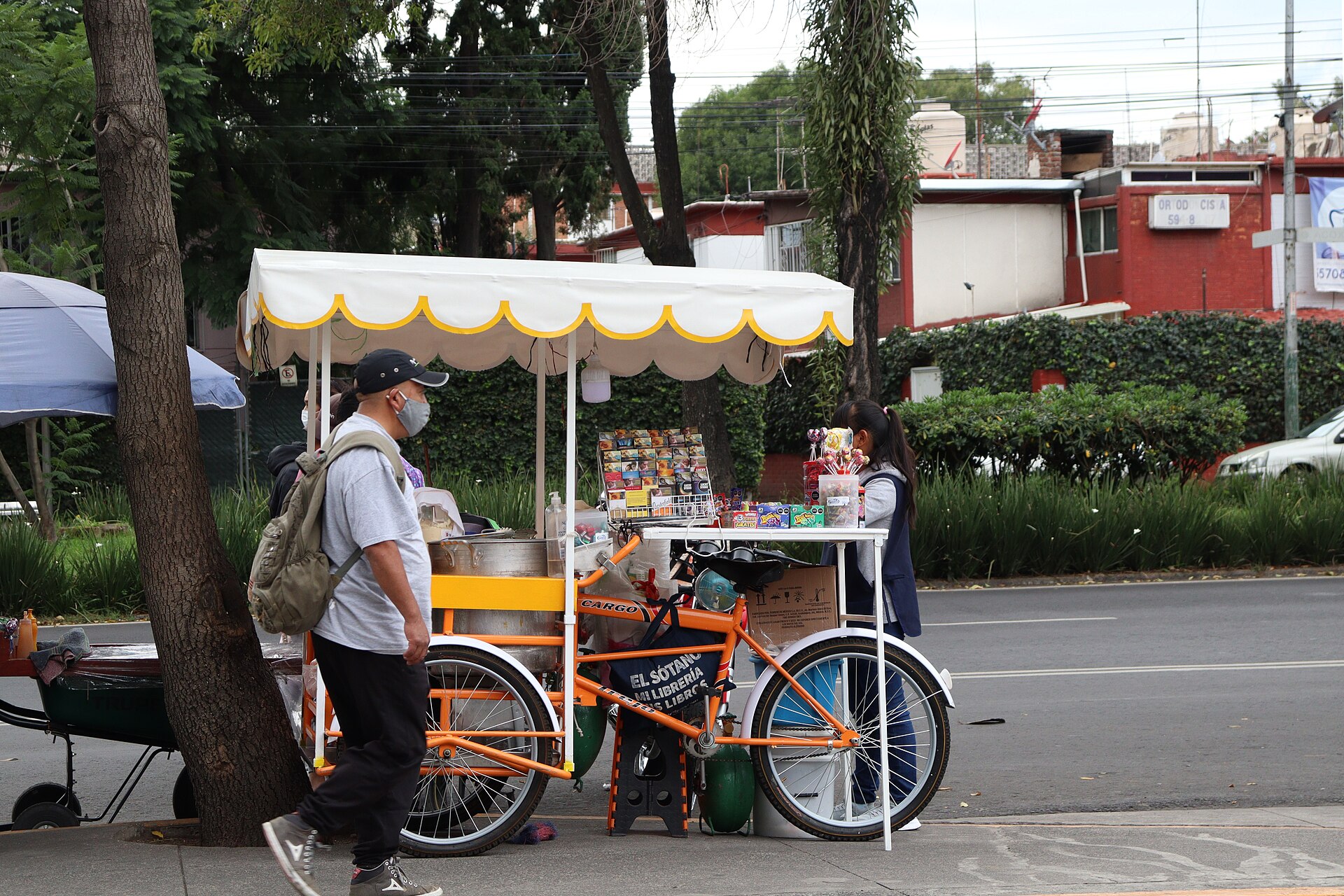 A street cart in Mexico City selling snacks and sweets, with awning and display cases