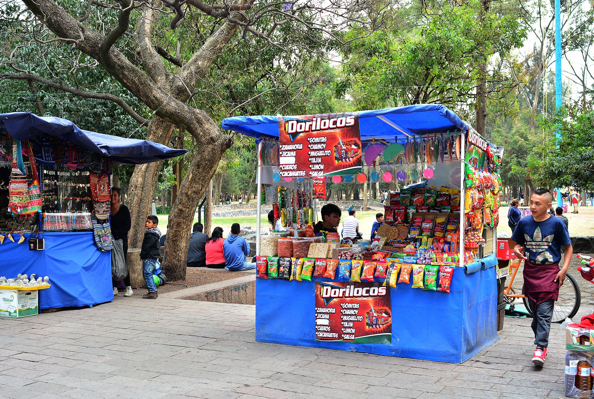 A street stand in Mexico City advertising dorilocos, with bags of chips and containers of toppings on display