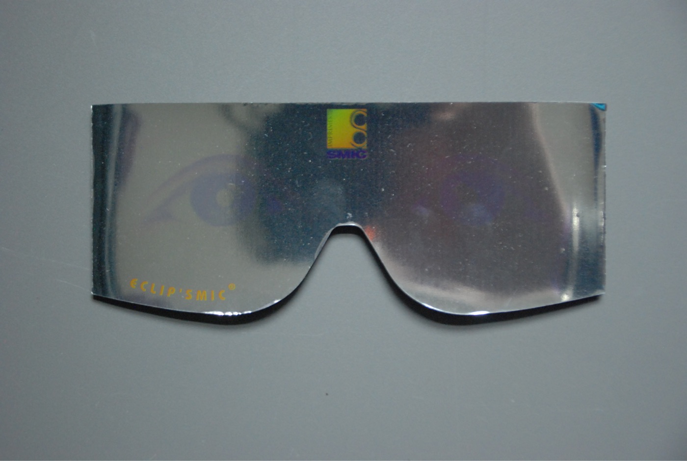 A wrap-around visor of silver aluminised film, printed with a small logo and the word ECLIP'SMIC in orange