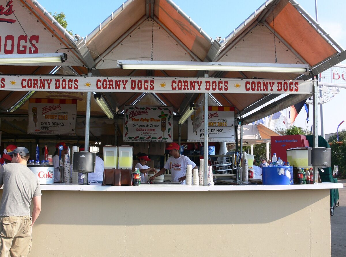 A Fletcher's Corny Dogs stand at the State Fair of Texas, with red-and-white awnings reading CORNY DOGS