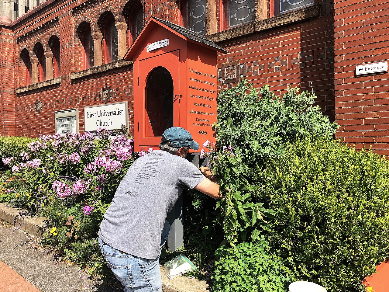 A steward repairing a weathered Little Free Library box