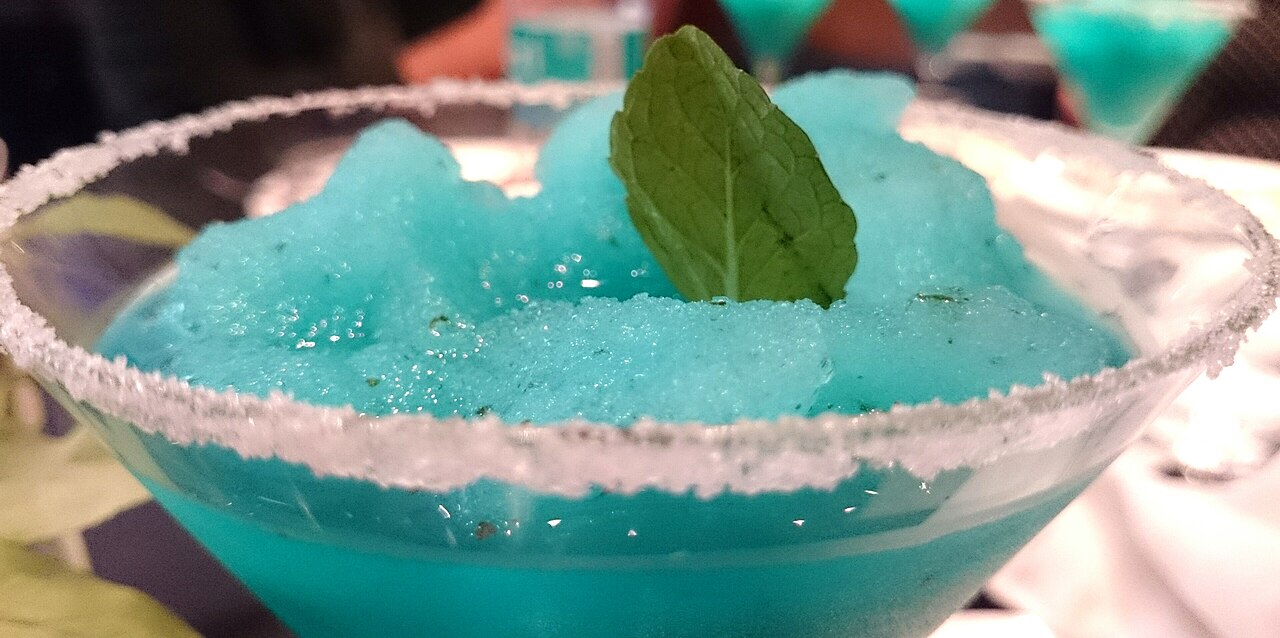 A machine swirling brilliant electric-blue slush, glistening and bright