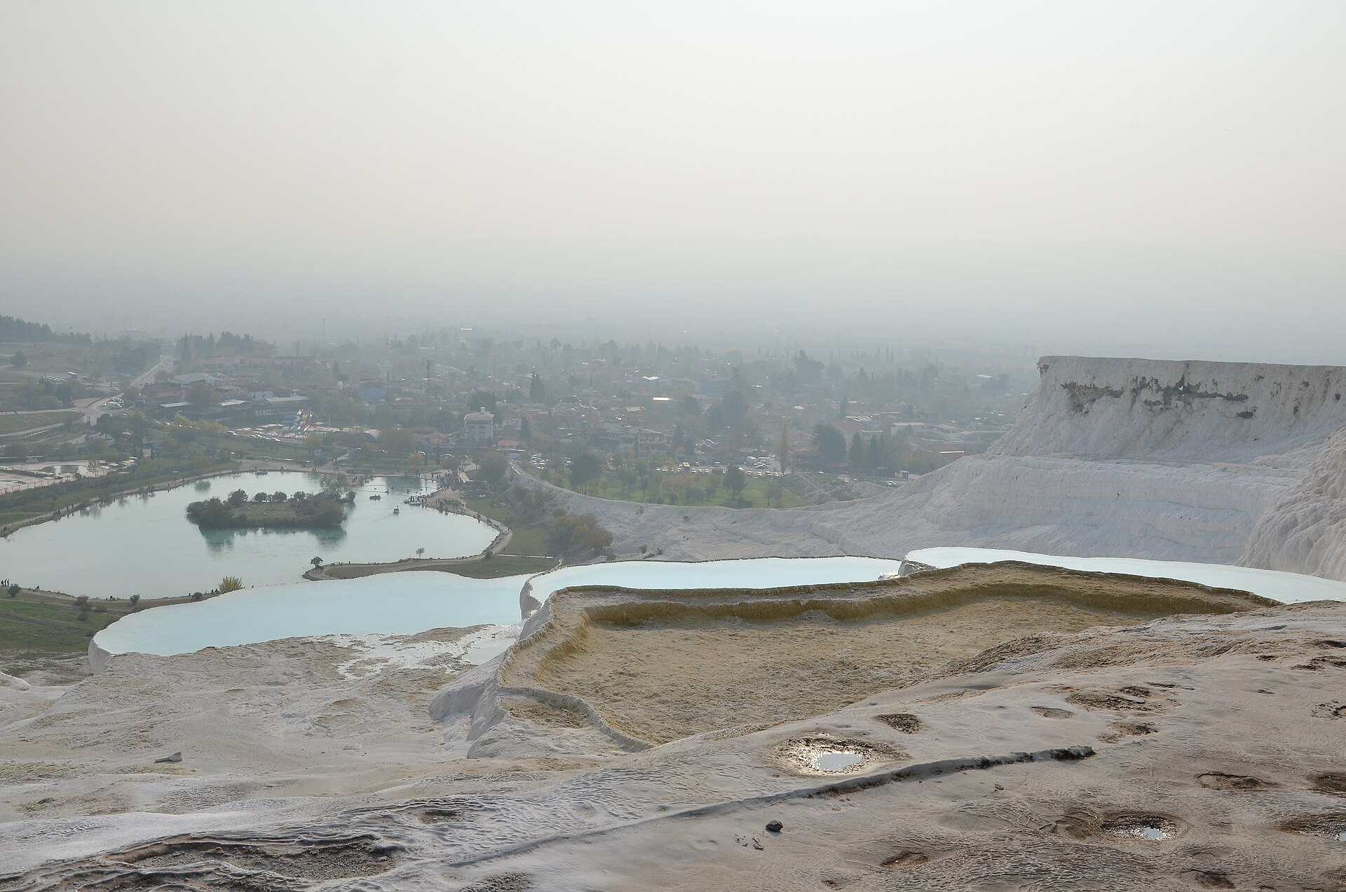 A broad overview of the shallow calcium carbonate pools of Pamukkale holding pale turquoise water