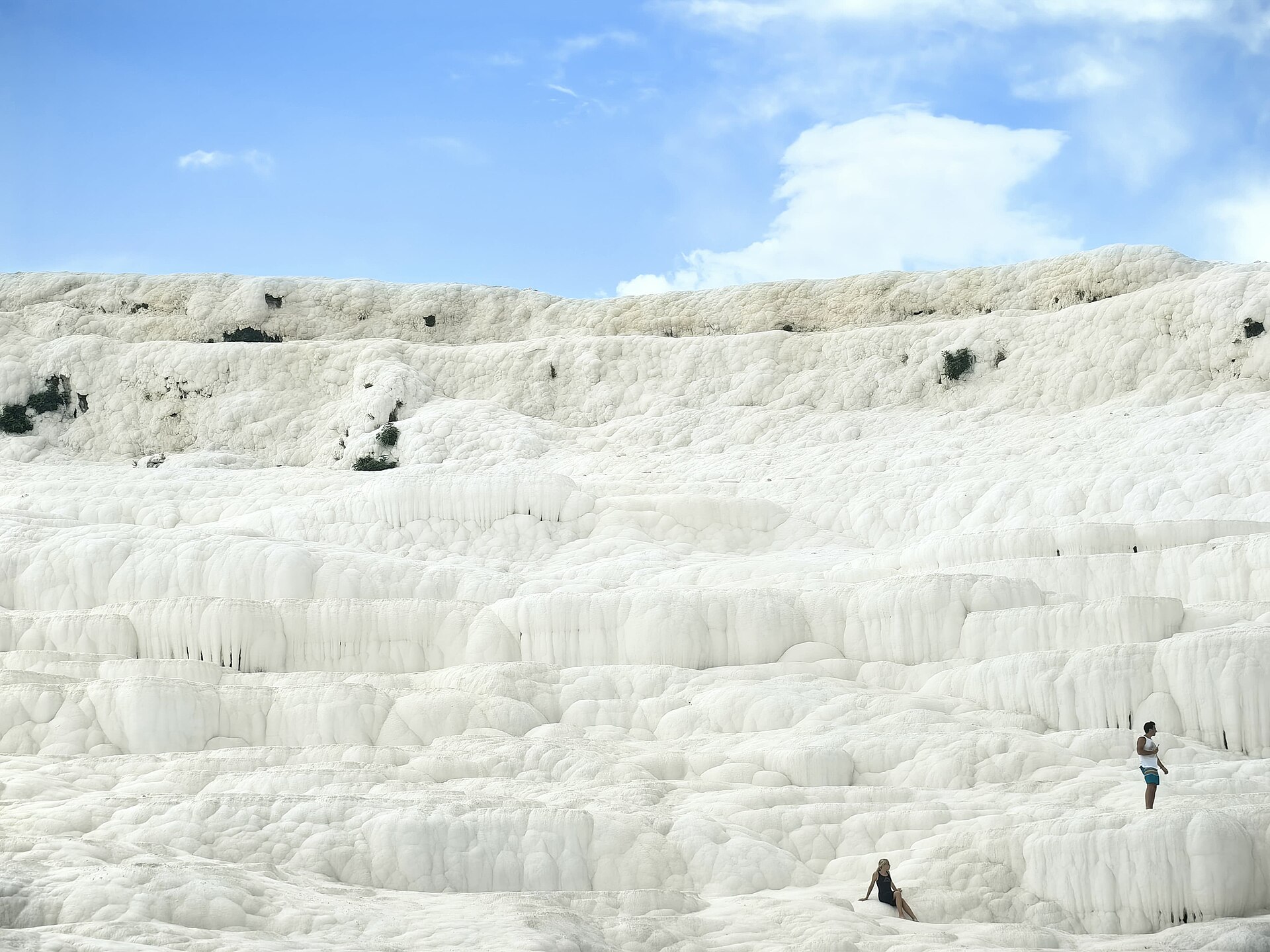 Close view of the rippled white travertine stone rims of Pamukkale, textured like frozen cloth