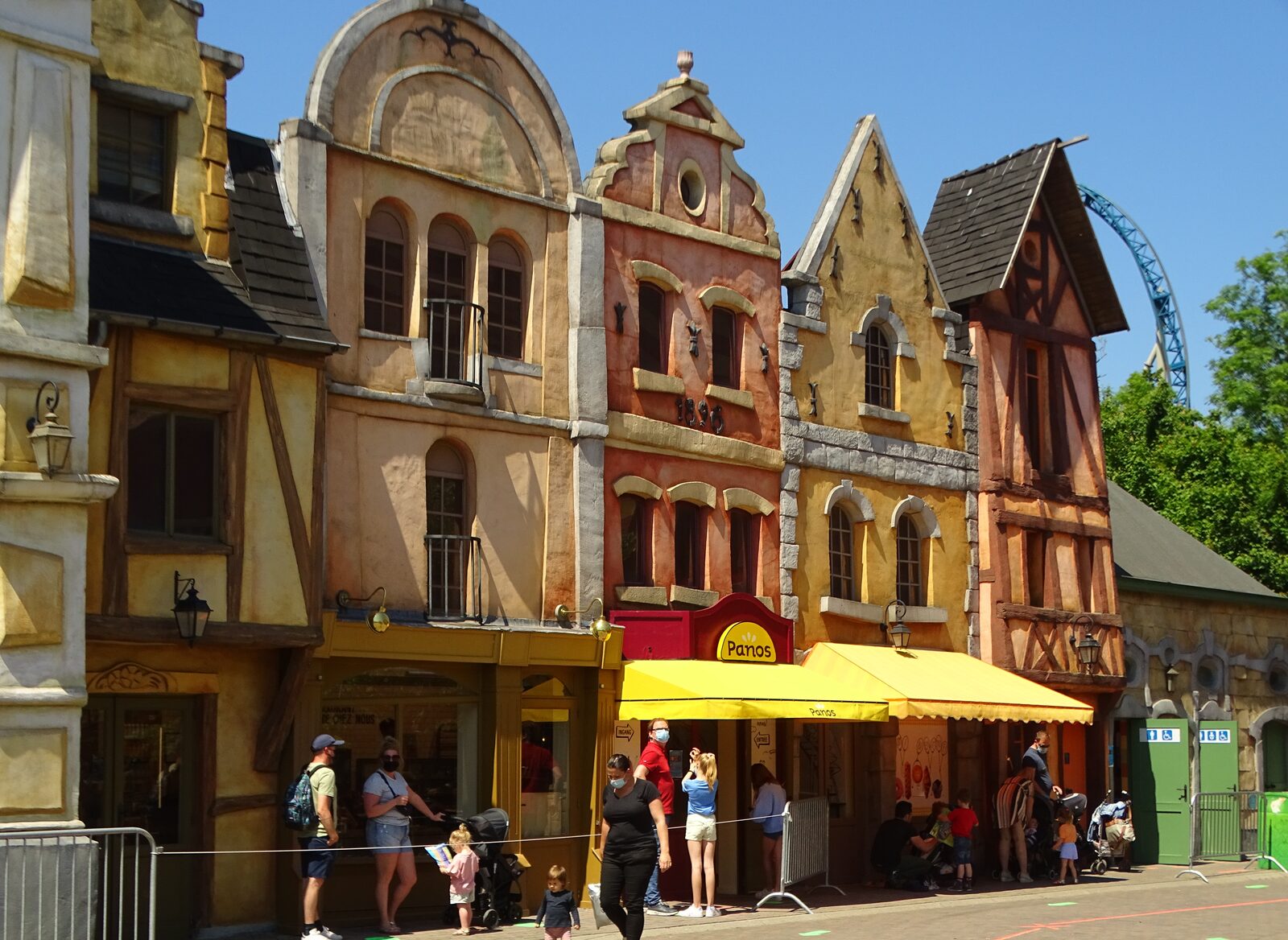 A colorful, storybook-themed village square at Plopsaland De Panne
