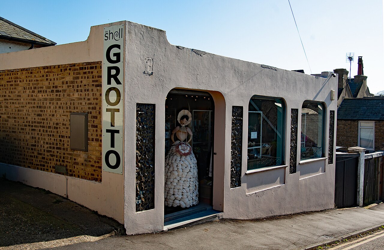 The modern street-level entrance to the Shell Grotto in Margate, with a shell-covered dress in the window