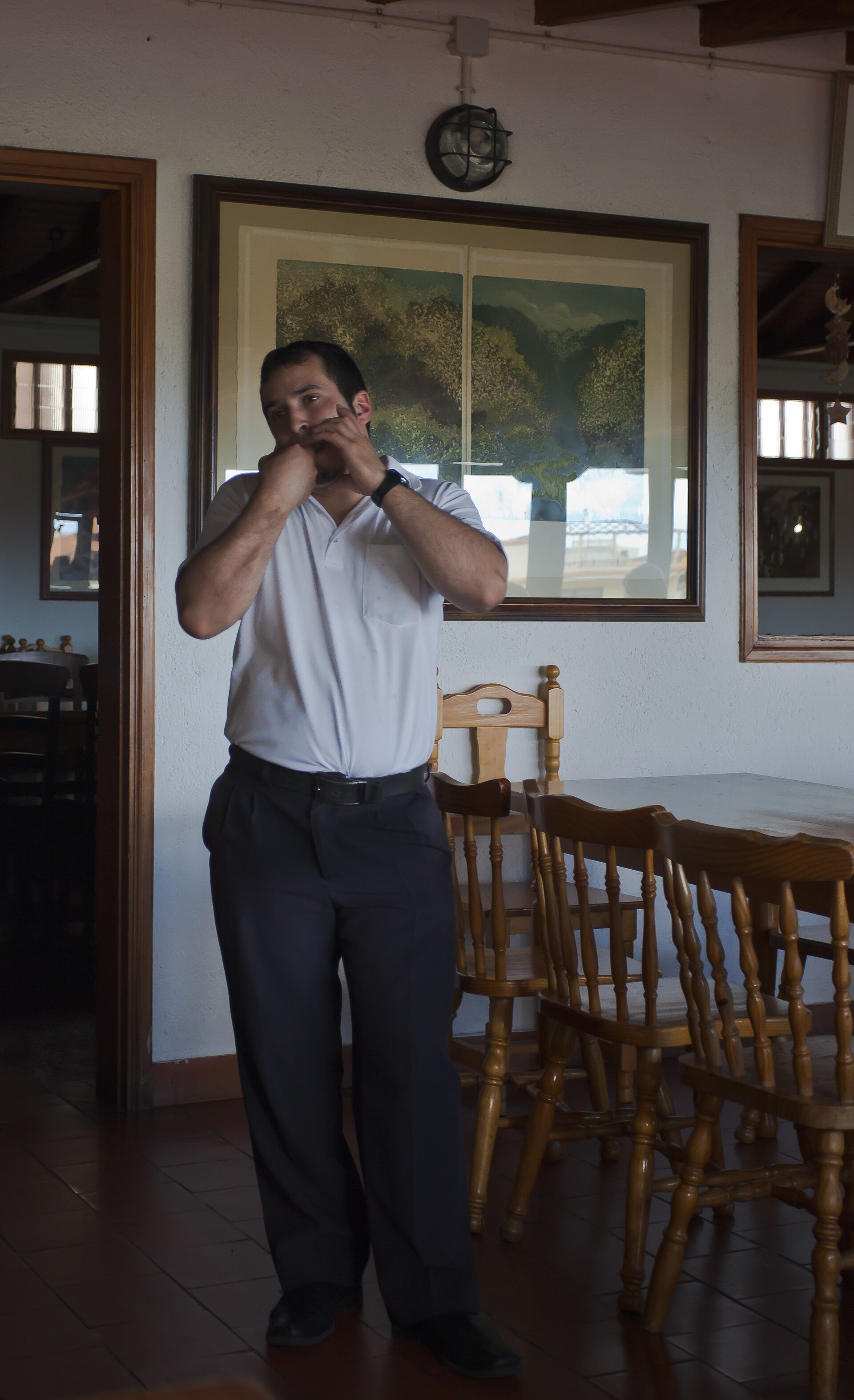 A man on La Gomera demonstrating Silbo Gomero, both hands cupped to his mouth to shape a whistle