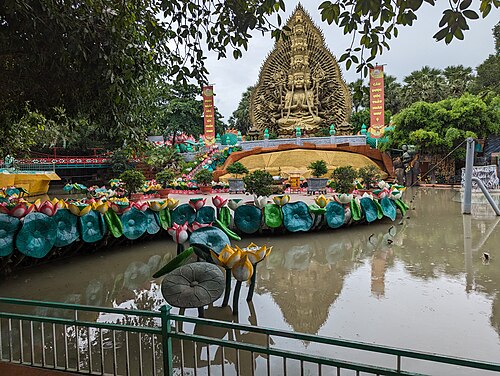 Ornate dragon structures and dragon boats on a lake at Suoi Tien