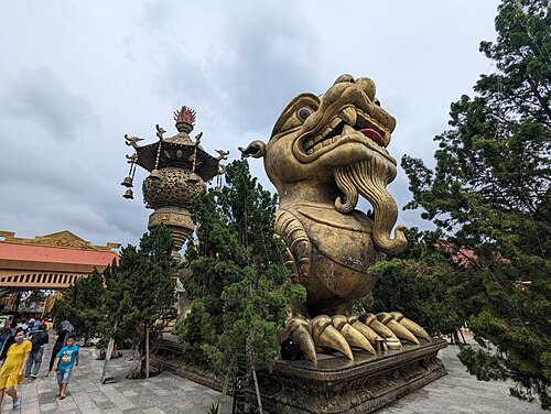 A giant ornate golden guardian beast statue at Suoi Tien