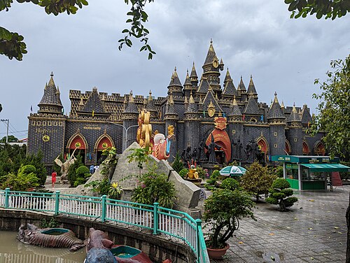 Ornate golden temple palace buildings at Suoi Tien with dragon-lined paths